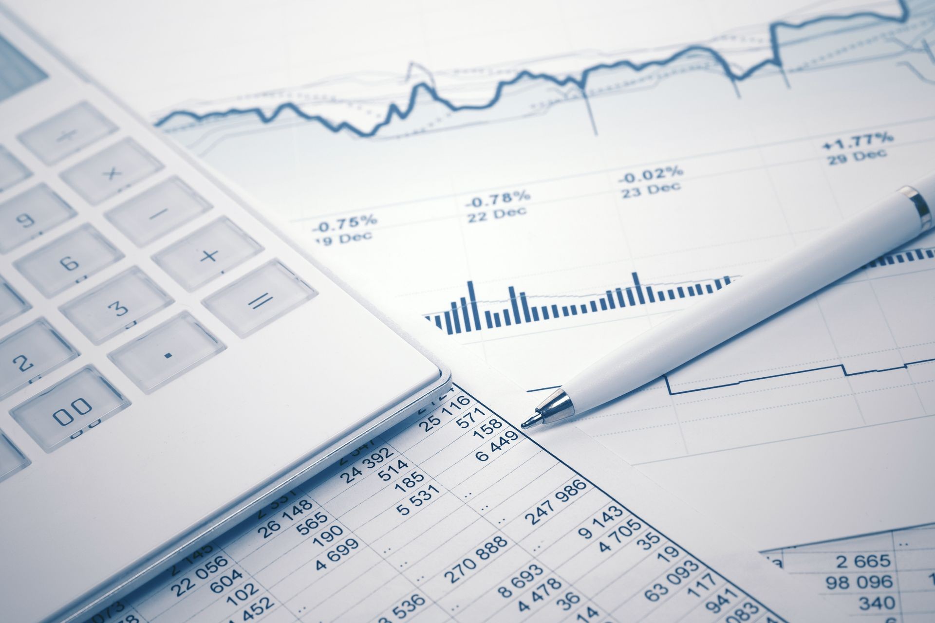 Financial accounting stock market graphs and charts analysis pen and calculator on balance sheets